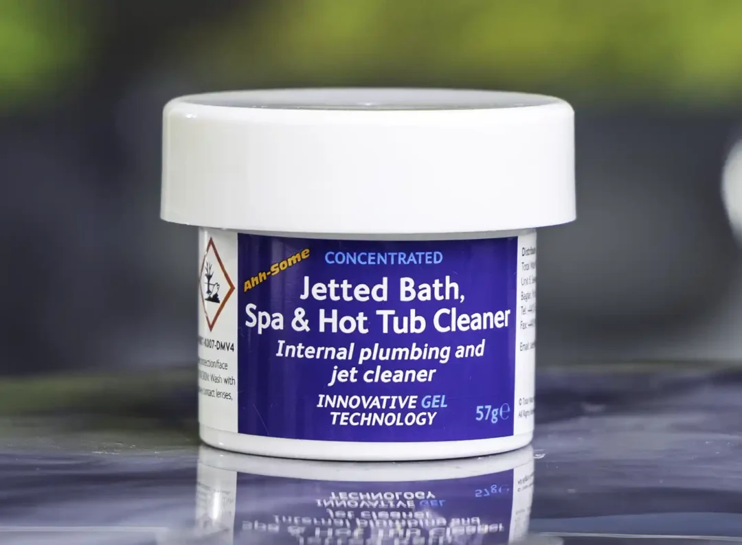 The front of a 57g tub of Ahh-Some Jetted bath, spa & hot tub cleaner on the edge of a hot tub