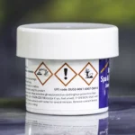 The left side of a 57g tub of Ahh-Some Jetted bath, spa & hot tub cleaner on the edge of a hot tub