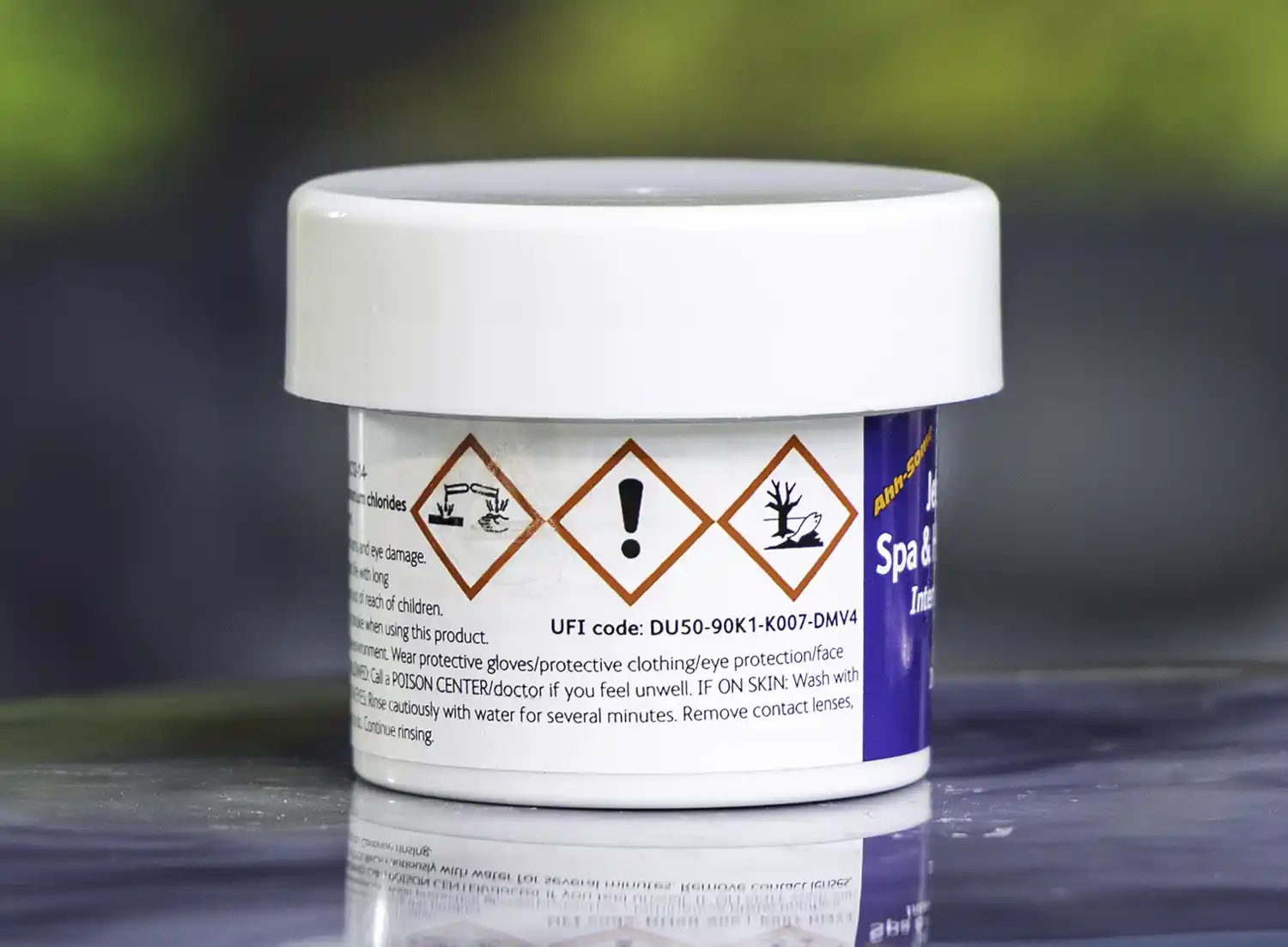 The left side of a 57g tub of Ahh-Some Jetted bath, spa & hot tub cleaner on the edge of a hot tub