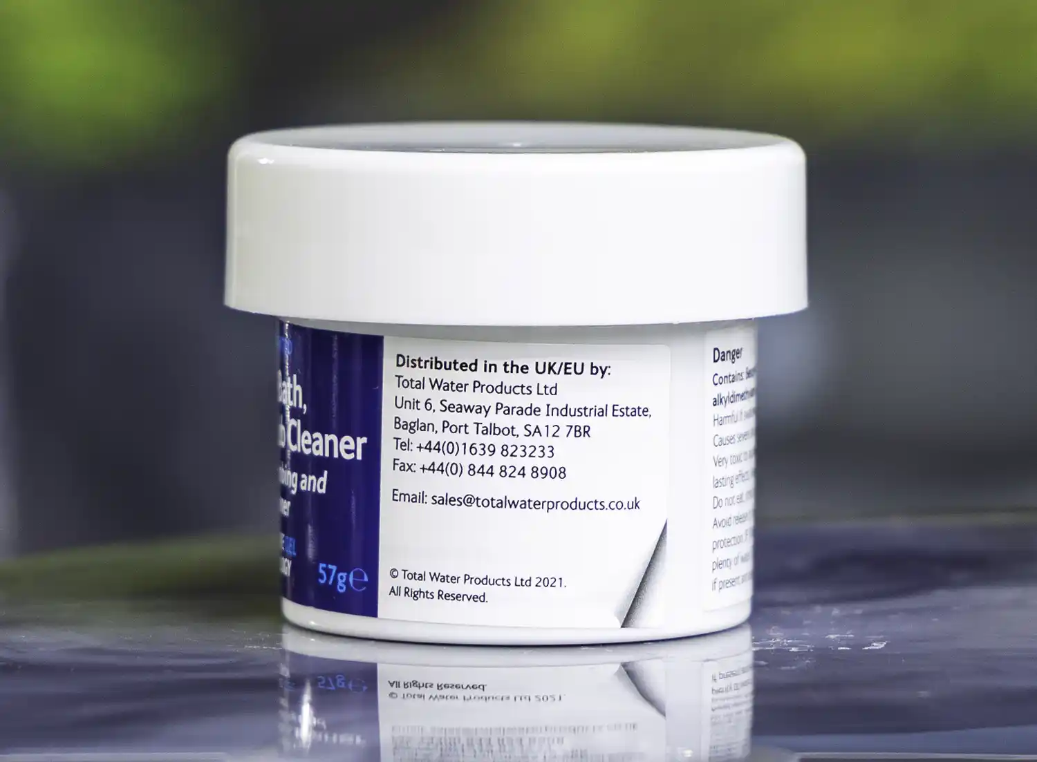The right side of a 57g tub of Ahh-Some Jetted bath, spa & hot tub cleaner on the edge of a hot tub
