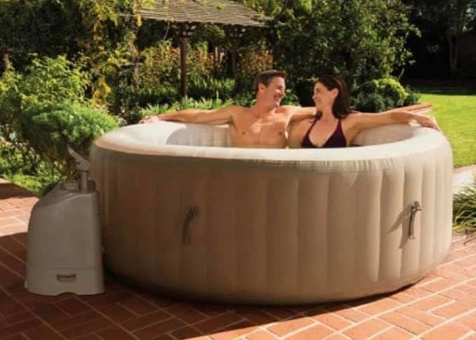 Couple relaxing in an beige inflatable hot tub on a sunny day.