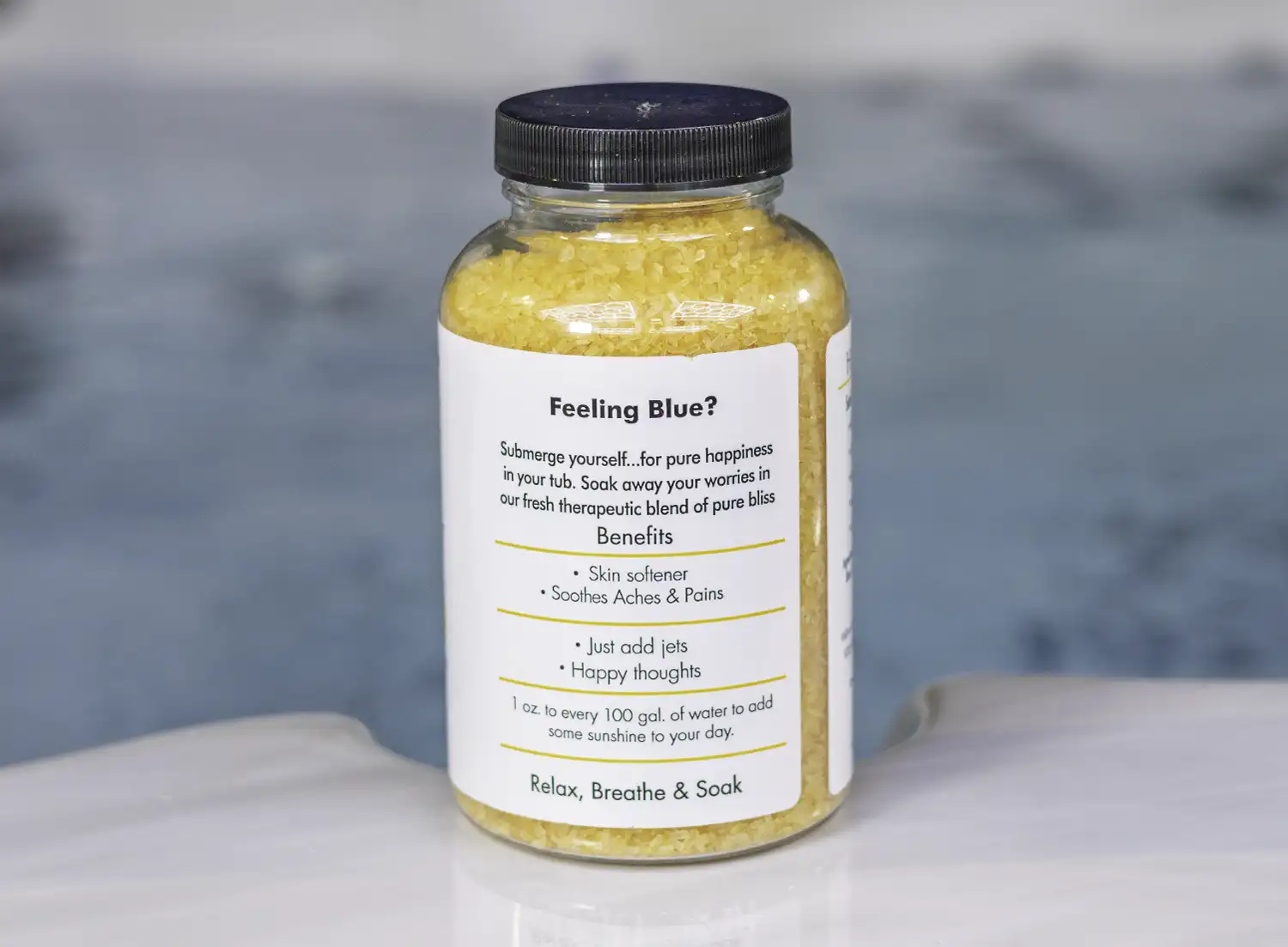 The right side of a 19oz tub of Spazazz Happy therapy hot tub aromatherapy crystals on the edge of a hot tub