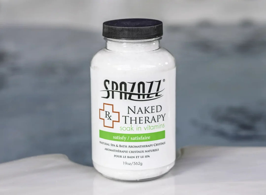 The front of a 19oz tub of Spazazz naked therapy hot tub aromatherapy crystals on the edge of a hot tub