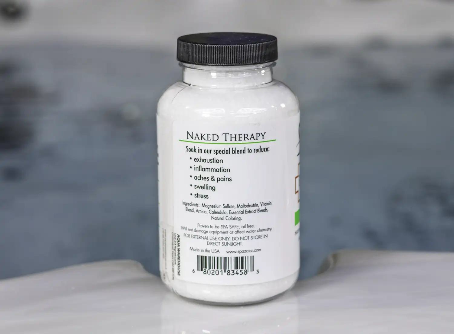 The right of a 19oz tub of Spazazz naked therapy hot tub aromatherapy crystals on the edge of a hot tub
