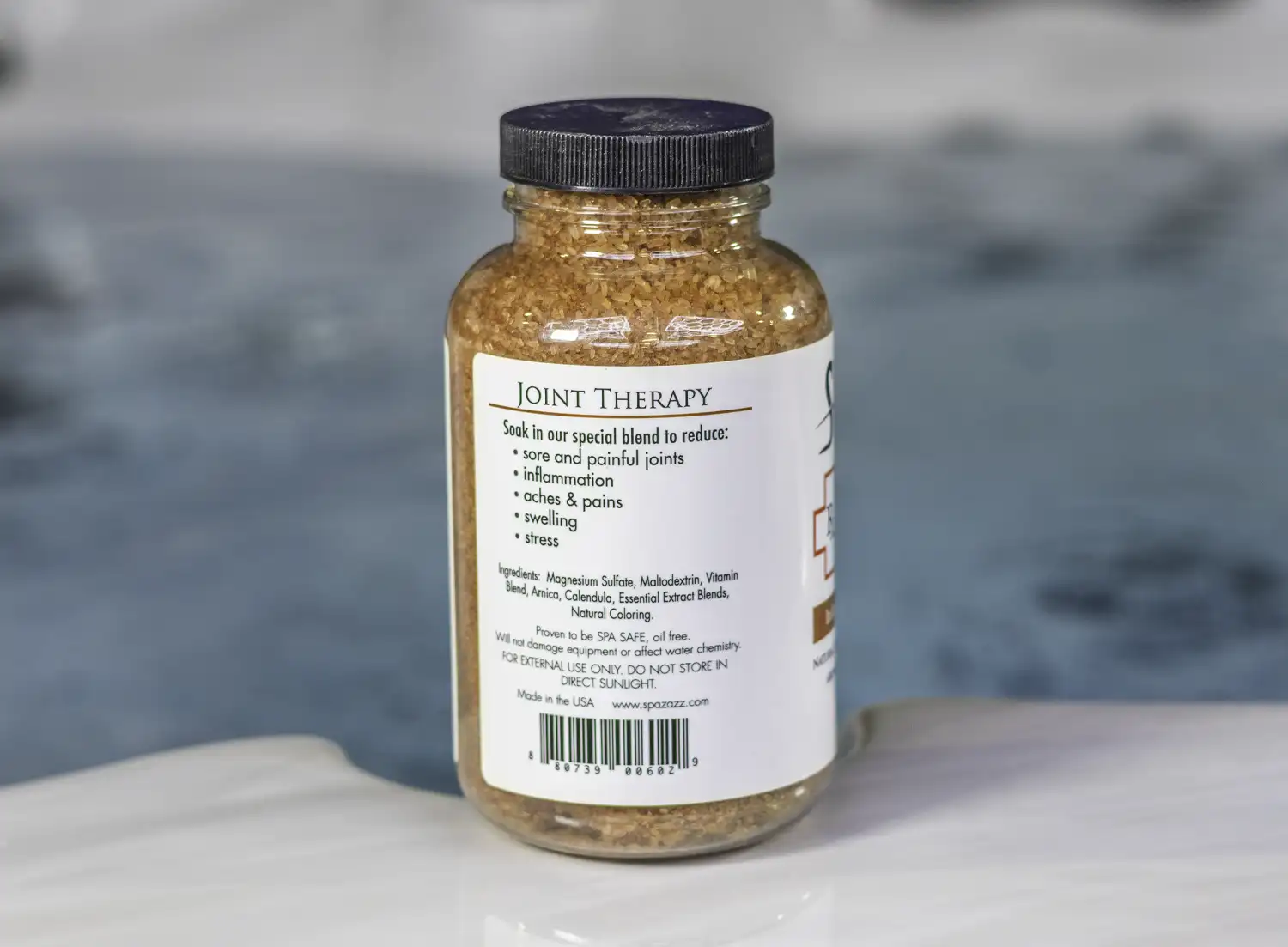 The left of a 19oz bottle of Spazazz joint Therapy on the side of a hot tub