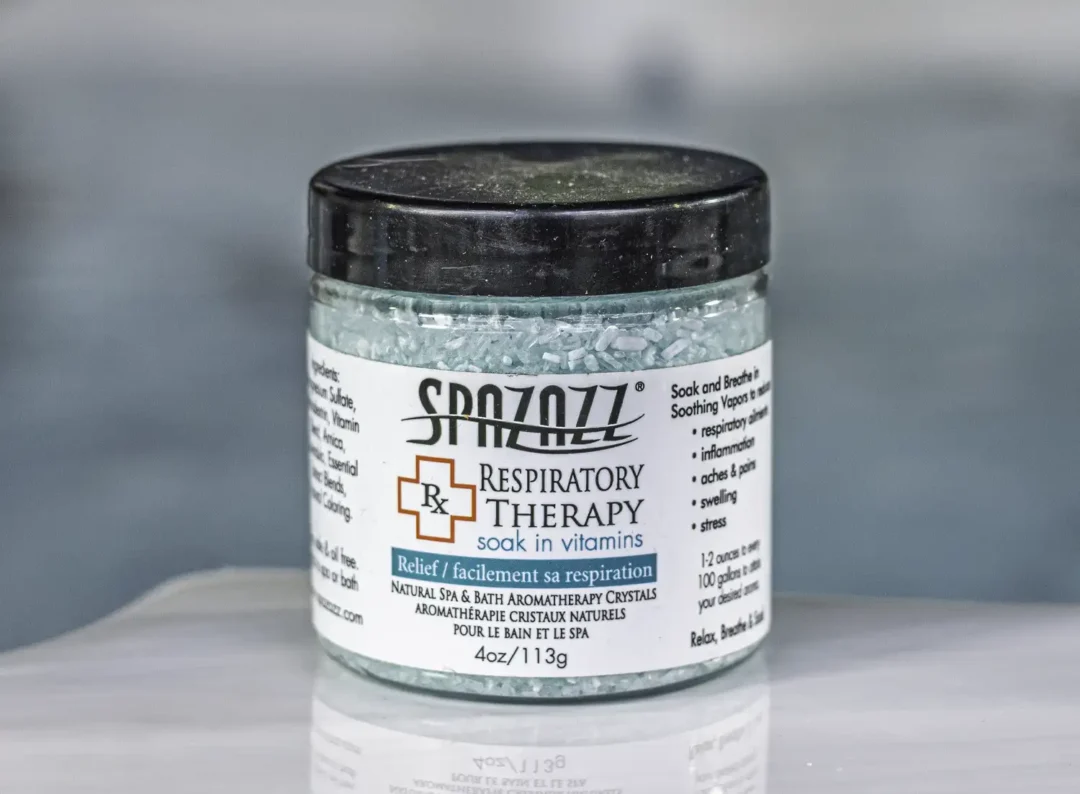 The front of a 4oz bottle of Spazazz respiratory Therapy hot tub aromatherapy crystals on the side of a hot tub