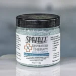 The front of a 4oz bottle of Spazazz respiratory Therapy hot tub aromatherapy crystals on the side of a hot tub