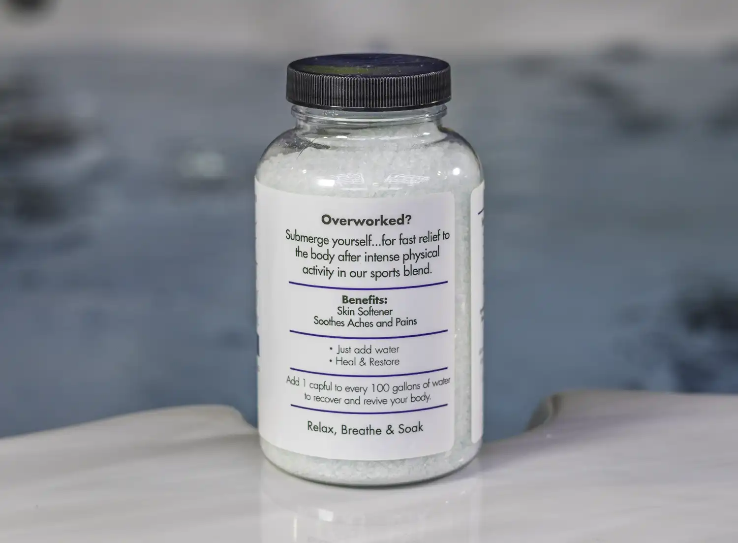 The right of a 19oz bottle of Spazazz sport Therapy hot tub aromatherapy crystals on the side of a hot tub