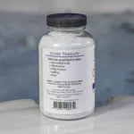 The left of a 19oz bottle of Spazazz sport Therapy hot tub aromatherapy crystals on the side of a hot tub