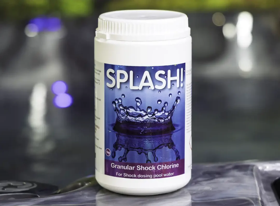 The front of a 1kg tub of Splash granular shock chlorine on the edge of a hot tub