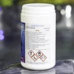 The right side of a 1kg tub of Splash granular shock chlorine on the edge of a hot tub